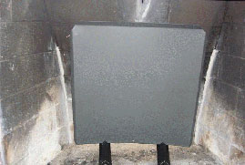 A heat shield in front of a masonry firebox repair