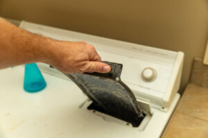 A lint screen removed from top of clothes dryer